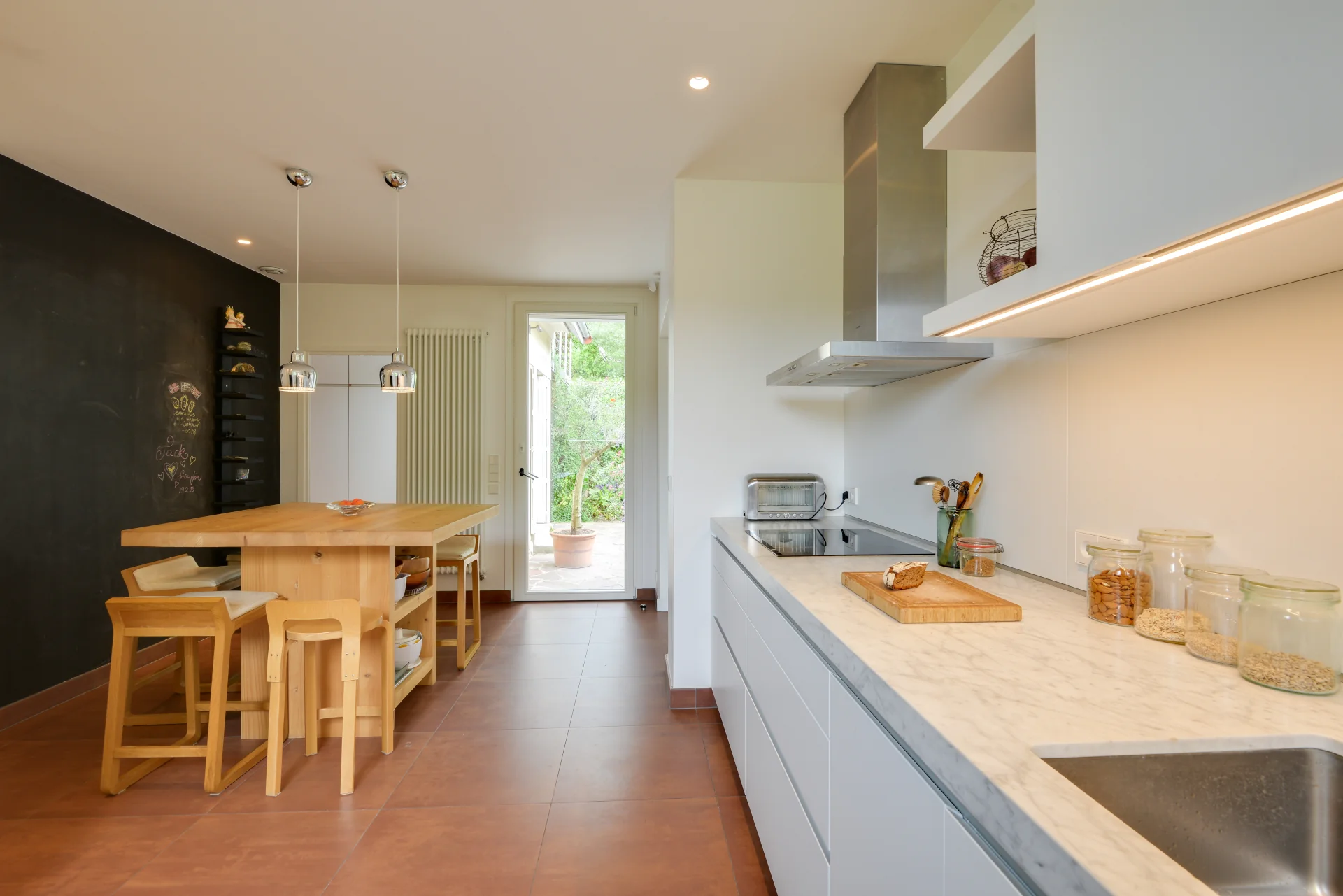 Cuisine aménagée avec Ilot central, tableau noir conçue par Nonjetable pour un projet d'architecture intérieur